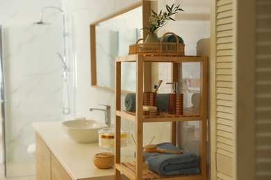 Shelving unit with toiletries in stylish bathroom interior 