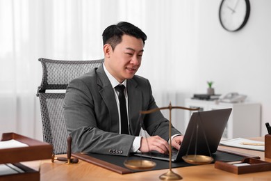 Notary working with laptop at wooden table in office