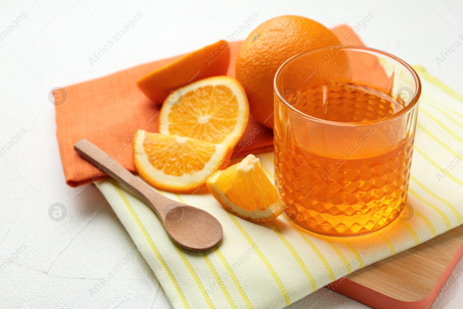 Photo of Board with tasty jelly and orange slices on light table, space for text