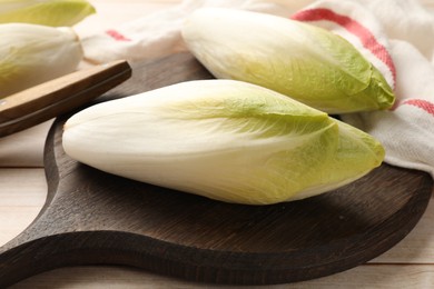 Photo of Raw ripe chicories on wooden table, closeup