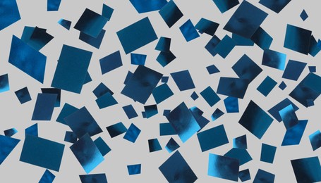 Image of Shiny blue confetti falling on grey background. Banner design