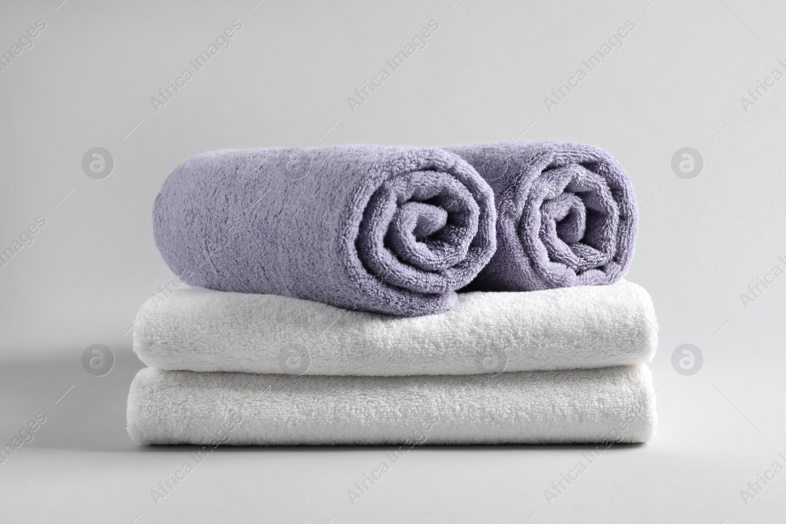 Photo of Stack of fresh fluffy towels on grey background