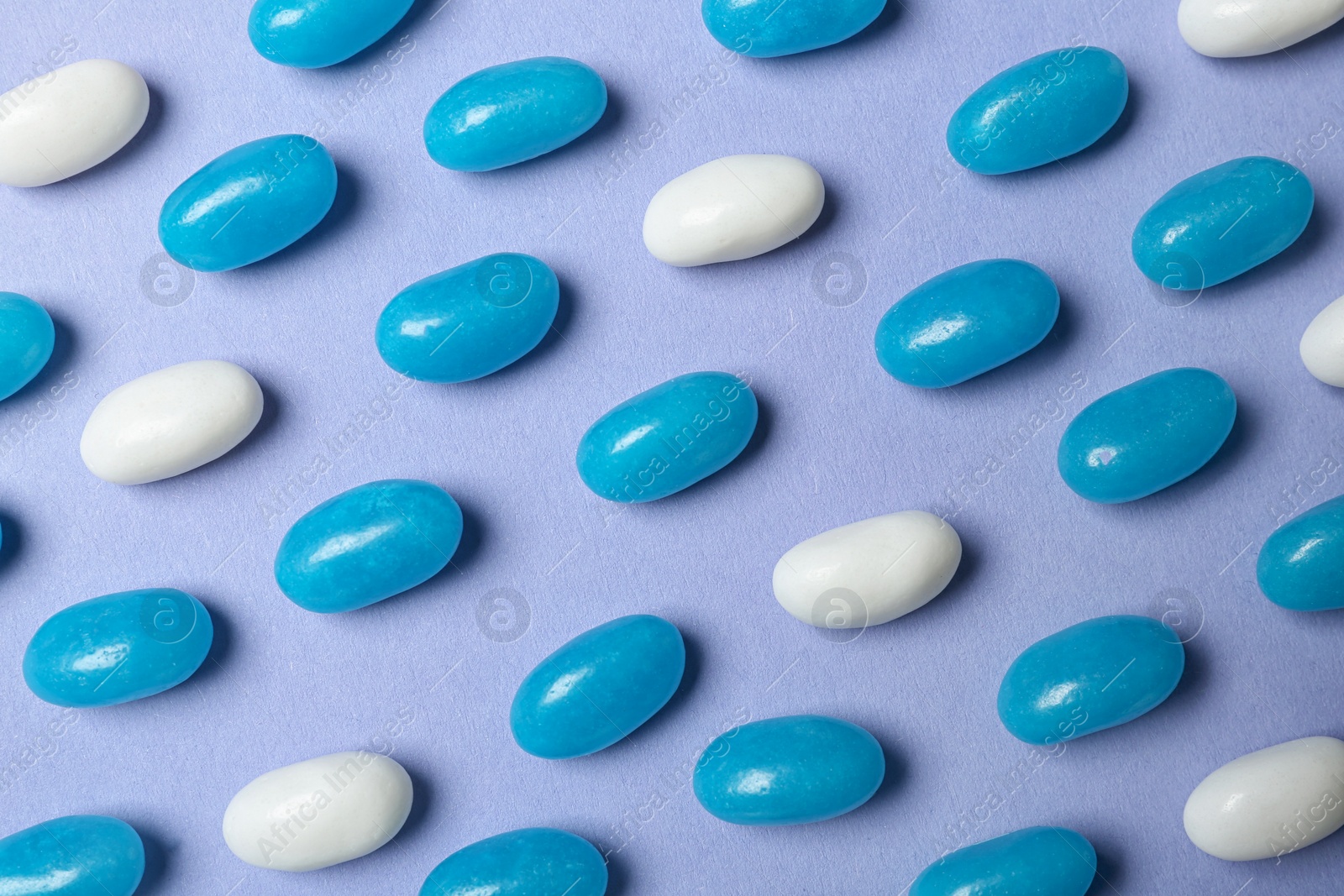 Photo of Many delicious jelly beans on color background, flat lay