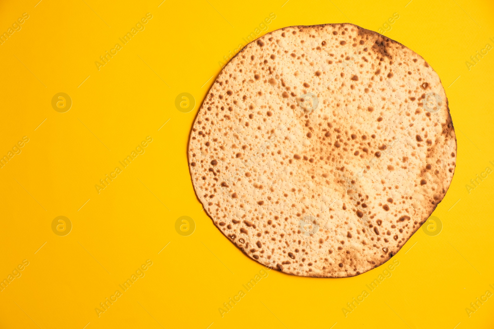 Photo of Tasty matzo on yellow background, top view with space for text. Passover (Pesach) celebration