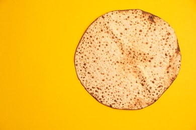 Photo of Tasty matzo on yellow background, top view with space for text. Passover (Pesach) celebration