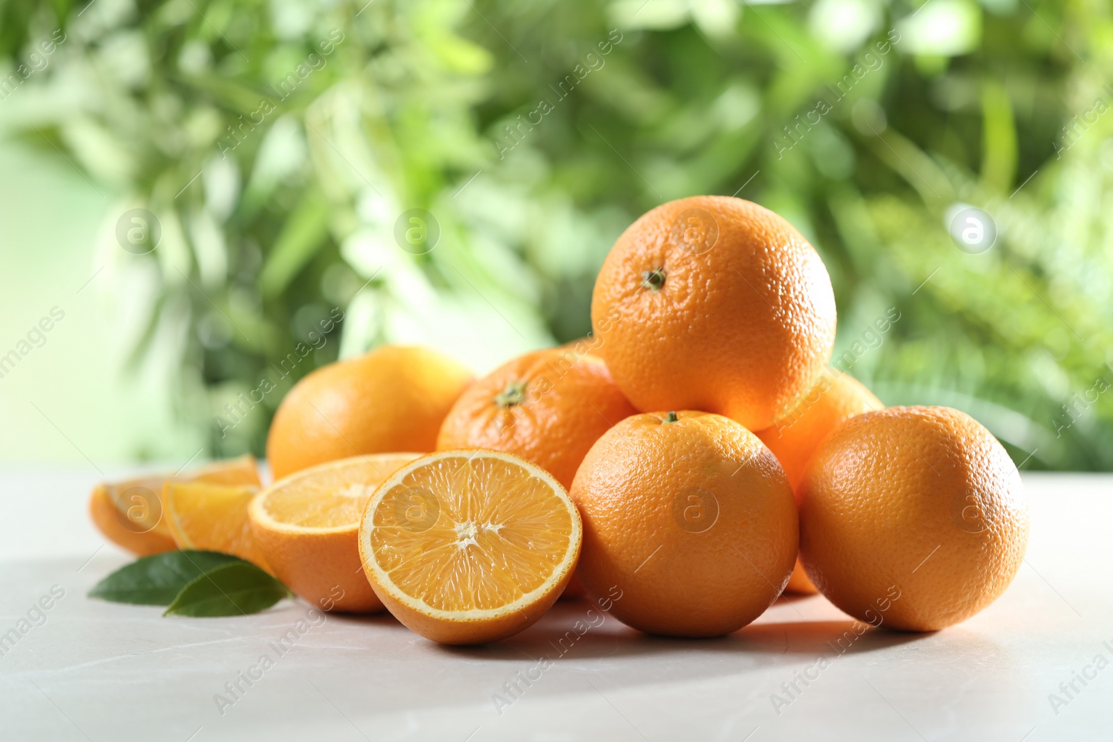 Photo of Ripe oranges on table against blurred background. Space for text