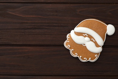 Santa Claus shaped Christmas cookie on wooden table, top view. Space for text