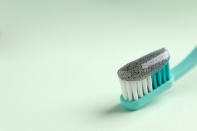 Photo of Brush with charcoal toothpaste on white background, closeup. Space for text