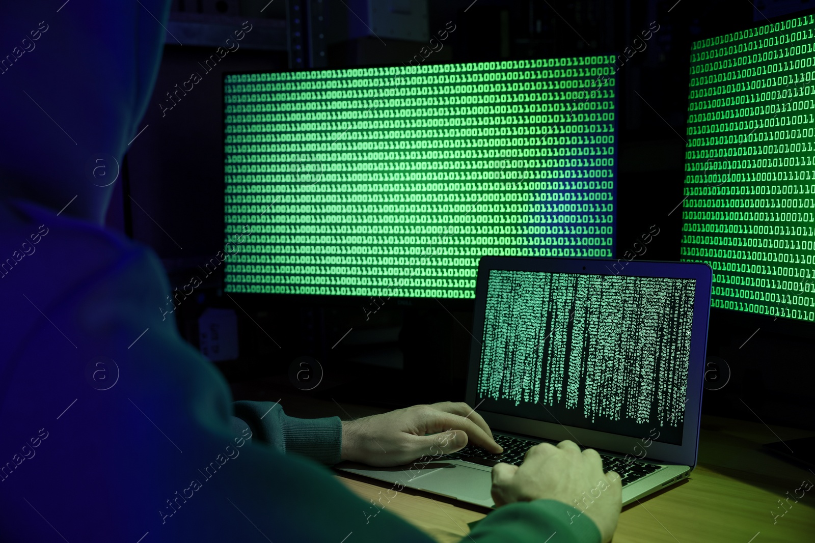 Photo of Hacker working with computers at wooden table, closeup. Cyber attack
