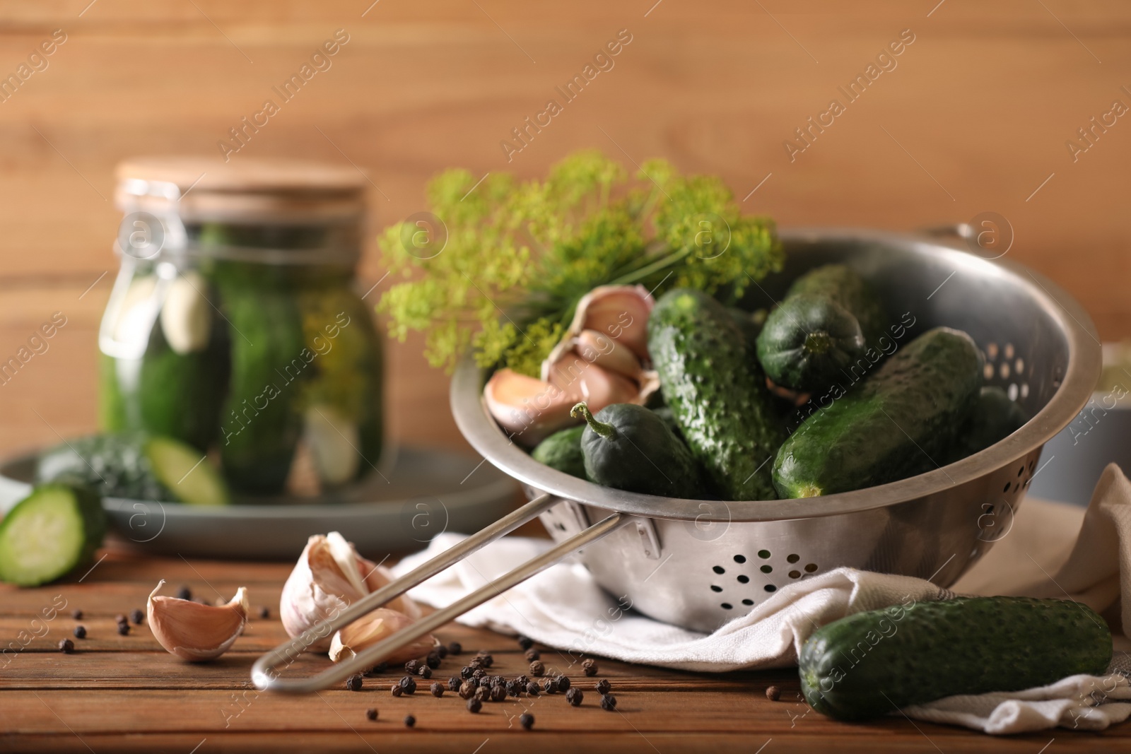 Photo of Fresh cucumbers, dill, peppercorns and garlic on wooden table. Pickling recipe