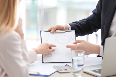 Photo of Young consultant working with client in office