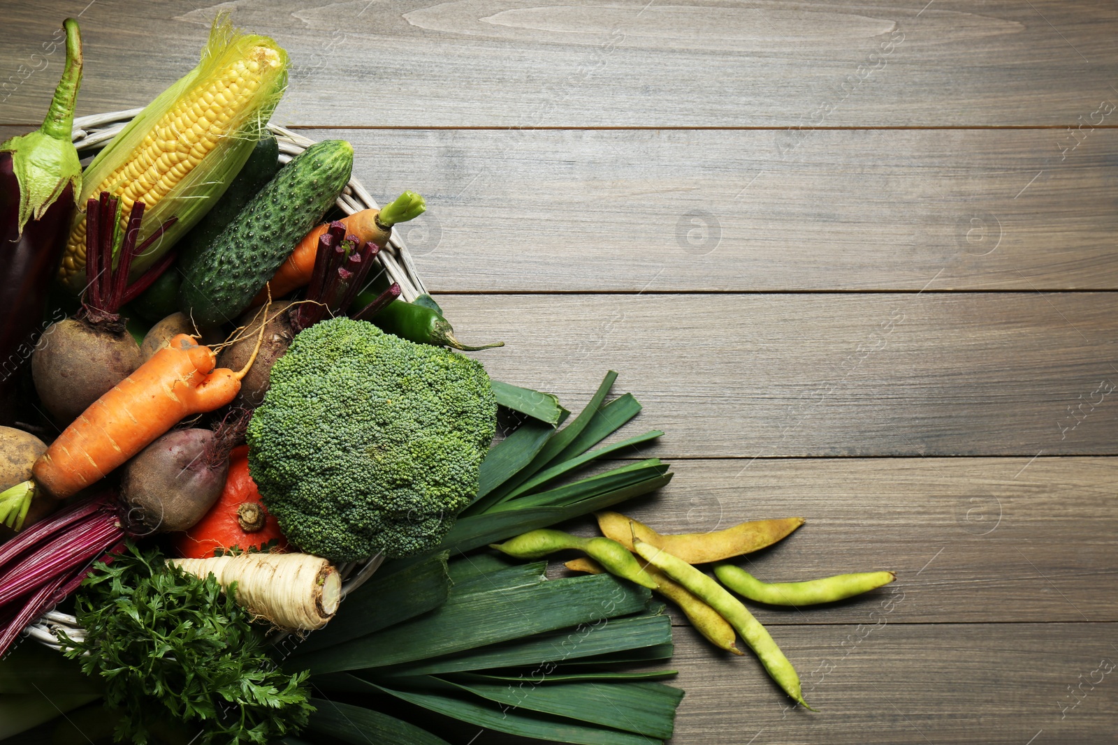 Photo of Different fresh ripe vegetables on wooden table, flat lay with space for text. Farmer produce