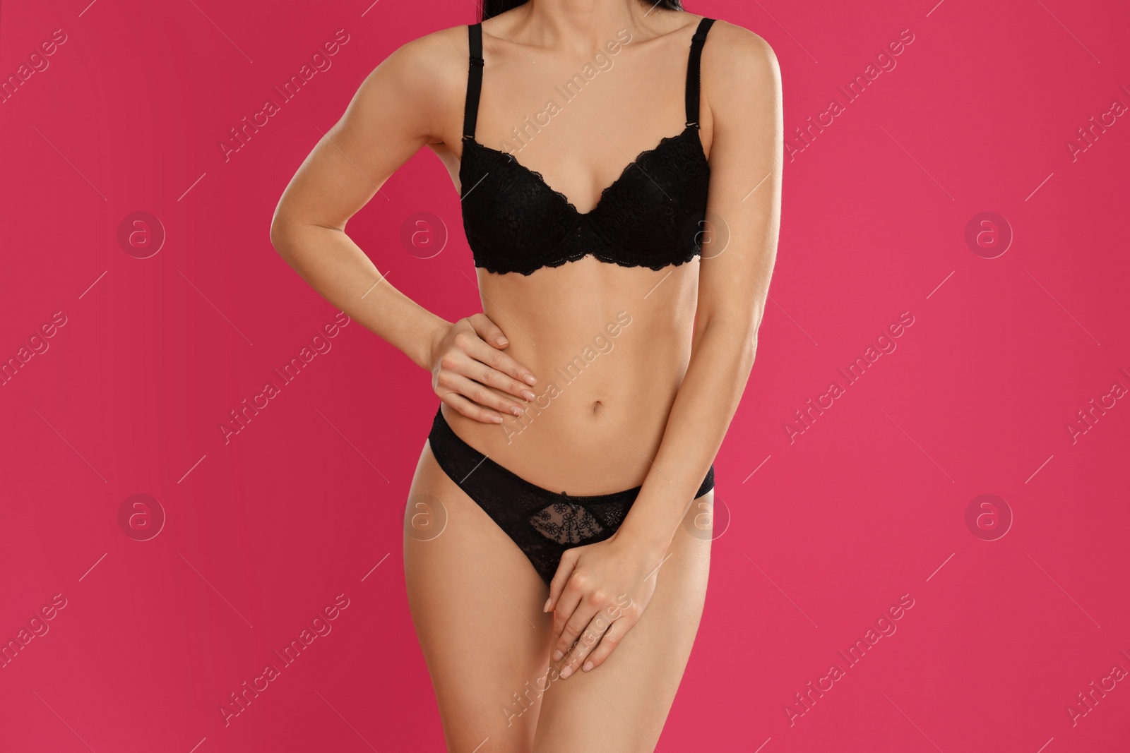 Photo of Young woman in black underwear on pink background, closeup