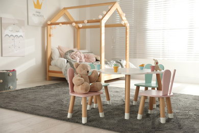 Small table and chairs with bunny ears in children's bedroom interior