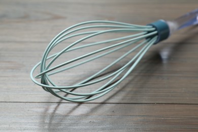 One whisk on wooden table, closeup. Kitchen tool