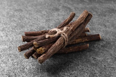 Dried sticks of liquorice root on grey table, closeup