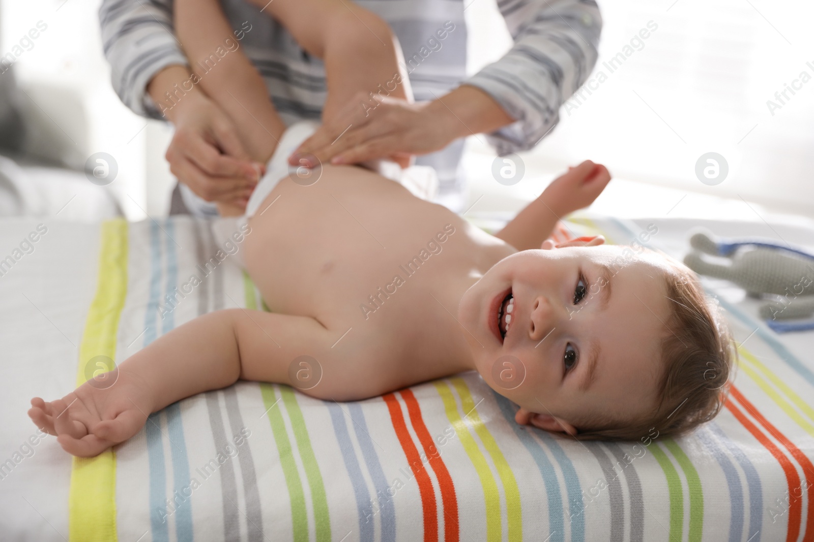 Photo of Mother changing baby's diaper on table at home