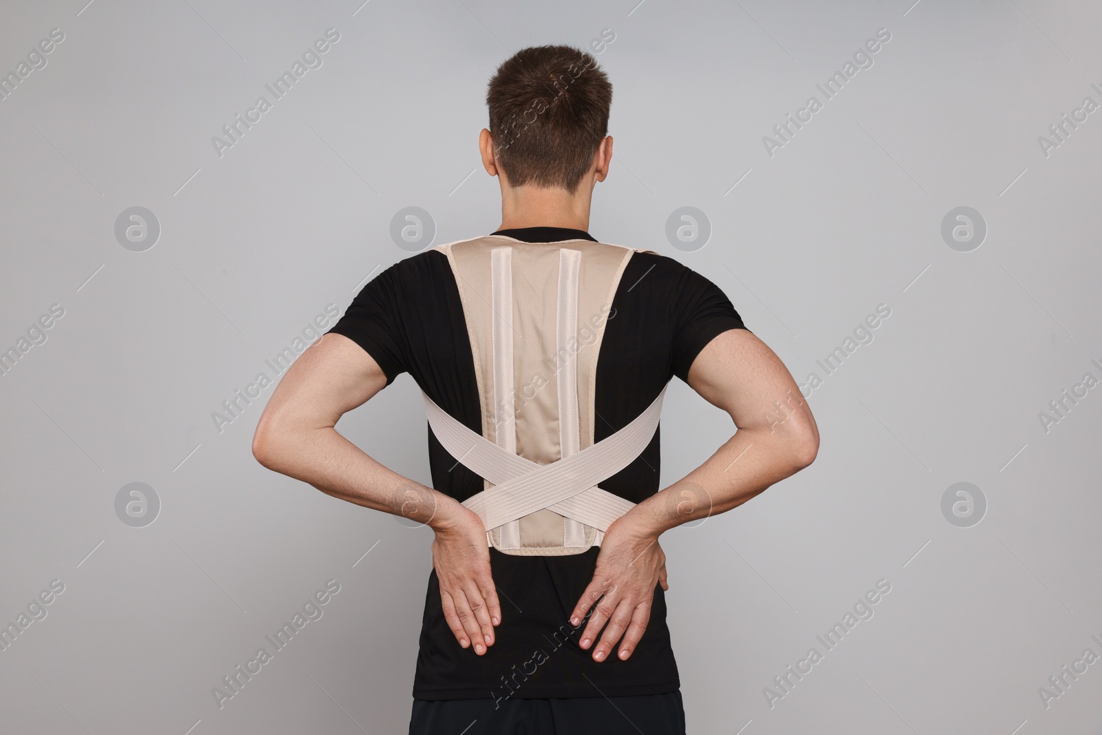 Photo of Man with orthopedic corset on grey background, back view