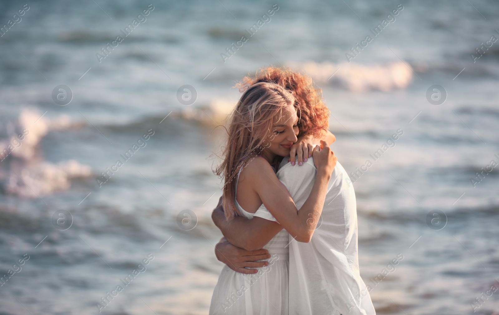 Photo of Young lovely couple on beach at sunset