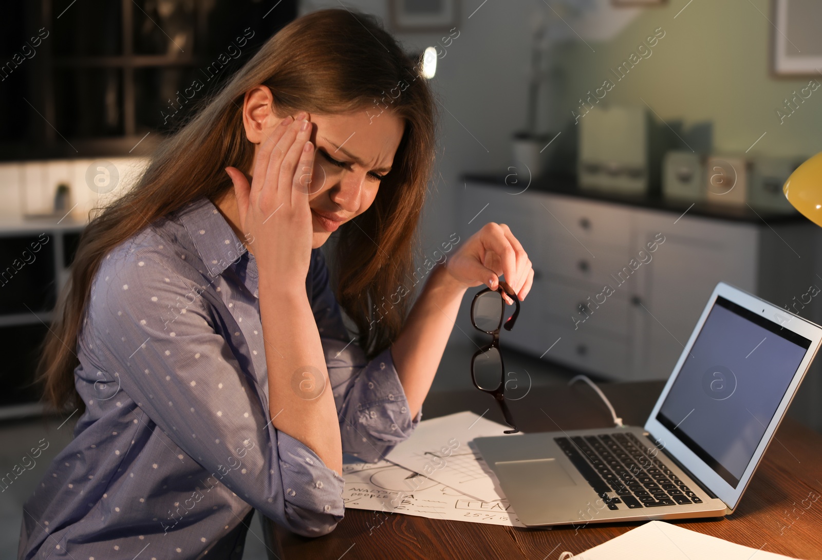 Photo of Overworked young woman with headache in office