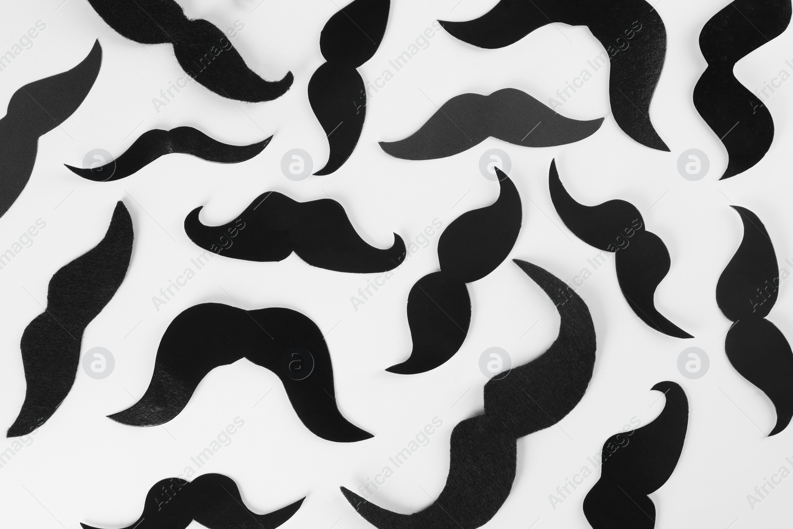 Photo of Fake paper mustaches on white background, flat lay