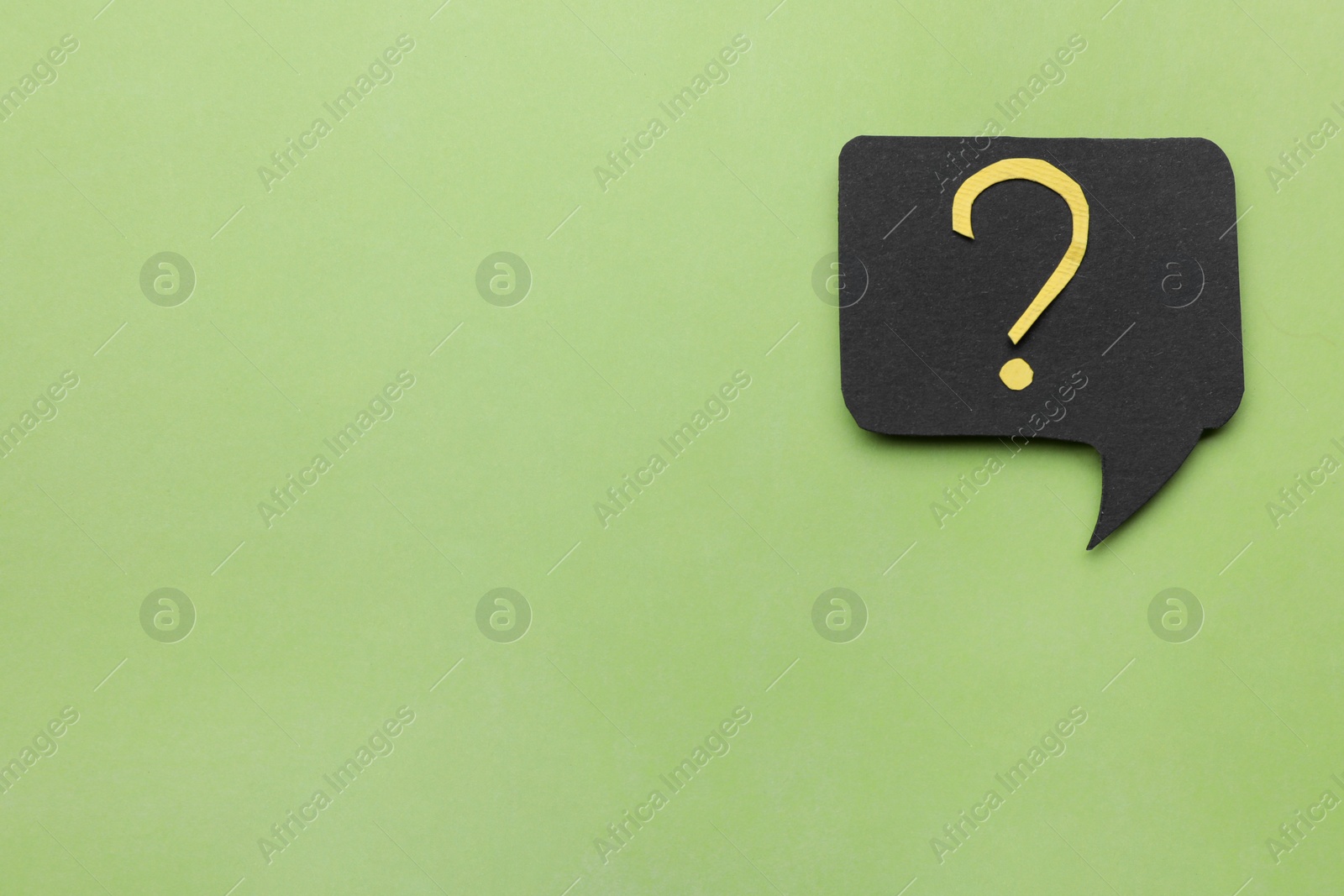 Photo of Paper speech bubble with question mark on green background, top view. Space for text