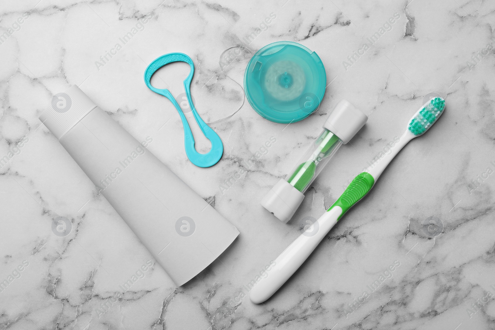 Photo of Flat lay composition with tongue cleaner and teeth care products on marble background