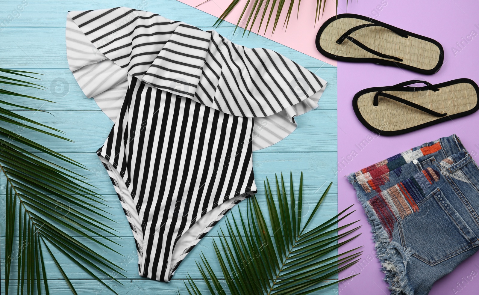 Photo of Flat lay composition with striped swimsuit and beach accessories on color background