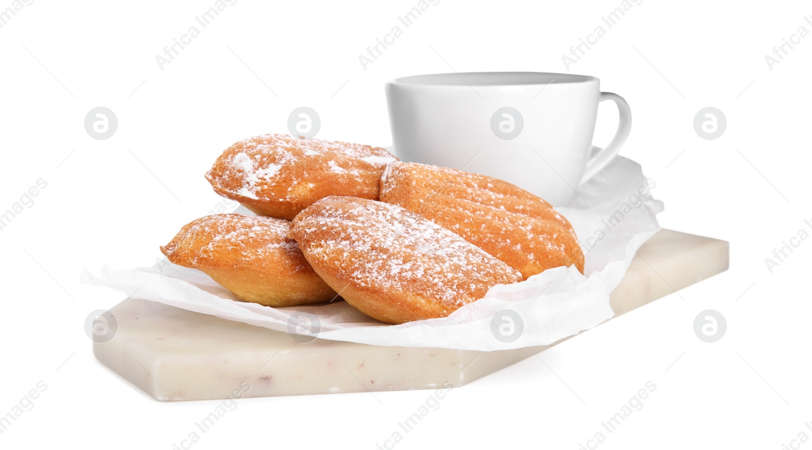 Photo of Delicious madeleine cakes with powdered sugar and tea on white background