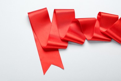 Photo of Beautiful red ribbon on white background, top view