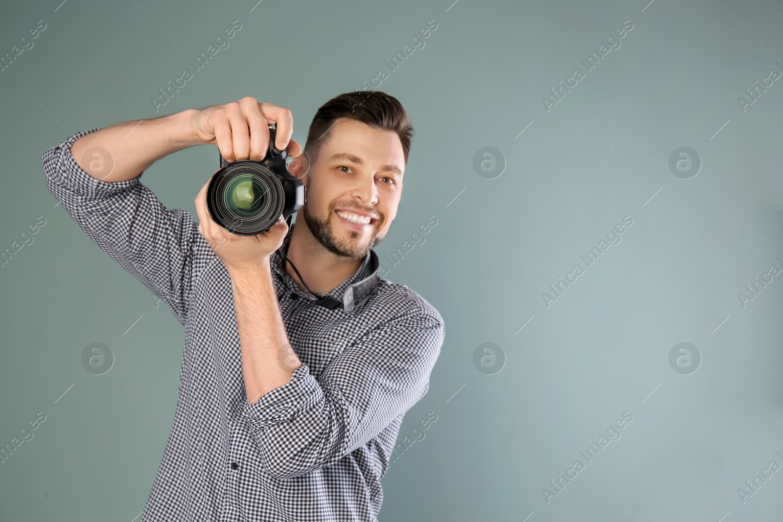 Photo of Male photographer with camera on grey background