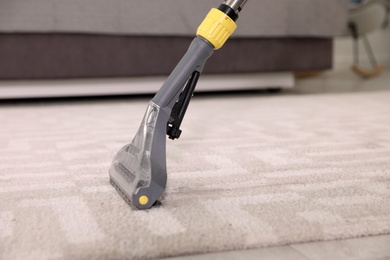 Photo of Removing dirt from carpet with vacuum cleaner indoors. Space for text