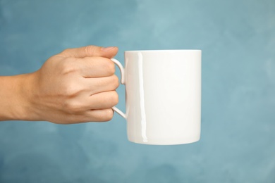 Woman holding ceramic cup on color background. Mock up for design