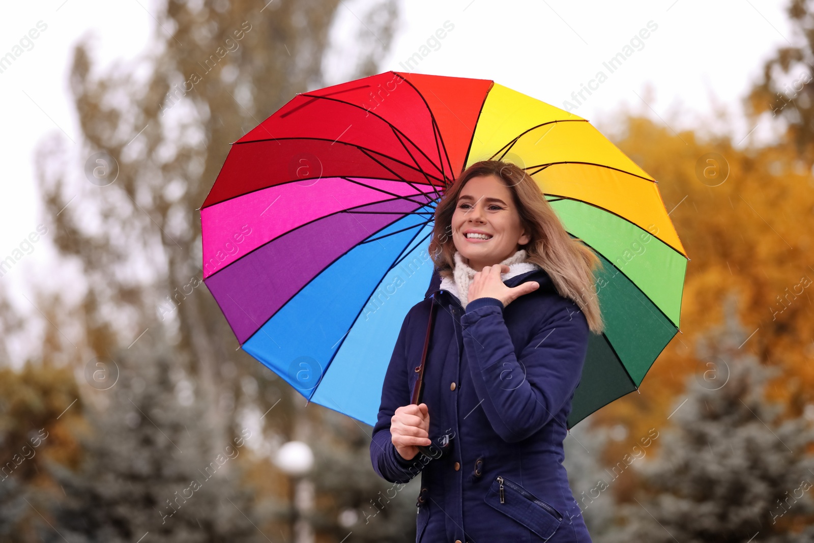 Photo of Woman with umbrella in autumn park on rainy day