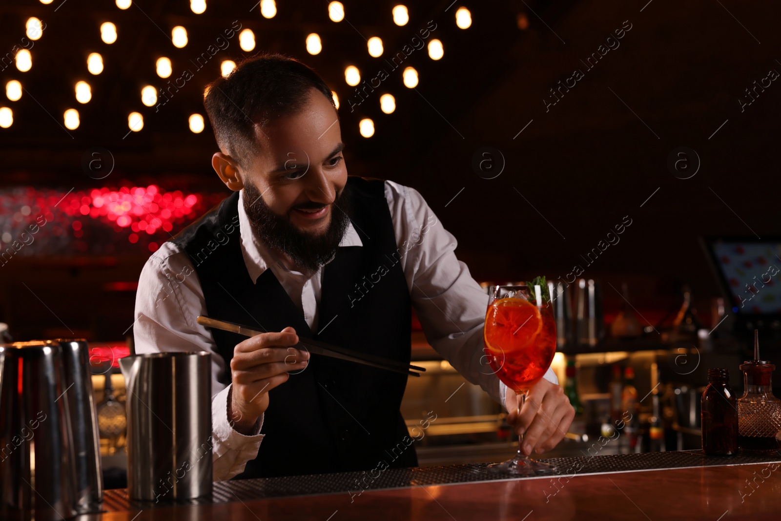 Photo of Bartender making fresh alcoholic cocktail at bar counter