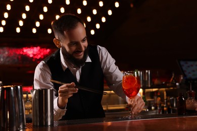 Photo of Bartender making fresh alcoholic cocktail at bar counter
