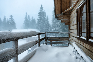 Photo of Cottage balcony covered with snow. Winter beauty