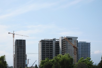 Photo of Construction site with tower cranes near unfinished buildings