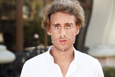 Image of Facial recognition system. Young man with digital biometric grid, outdoors