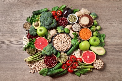 Photo of Fresh vegetables, fruits and seeds on wooden table, flat lay