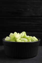 Photo of One bowl of fresh cut celery on grey table, closeup