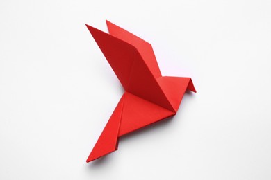 Photo of Beautiful red origami bird on white background, top view