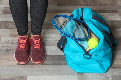 Photo of Young woman standing near sports bag, closeup