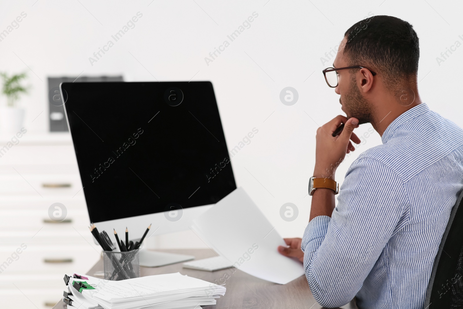 Photo of Businessman working with documents at wooden table in office