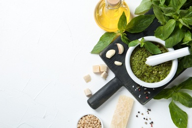 Photo of Flat lay composition with pesto sauce and ingredients on white table. Space for text