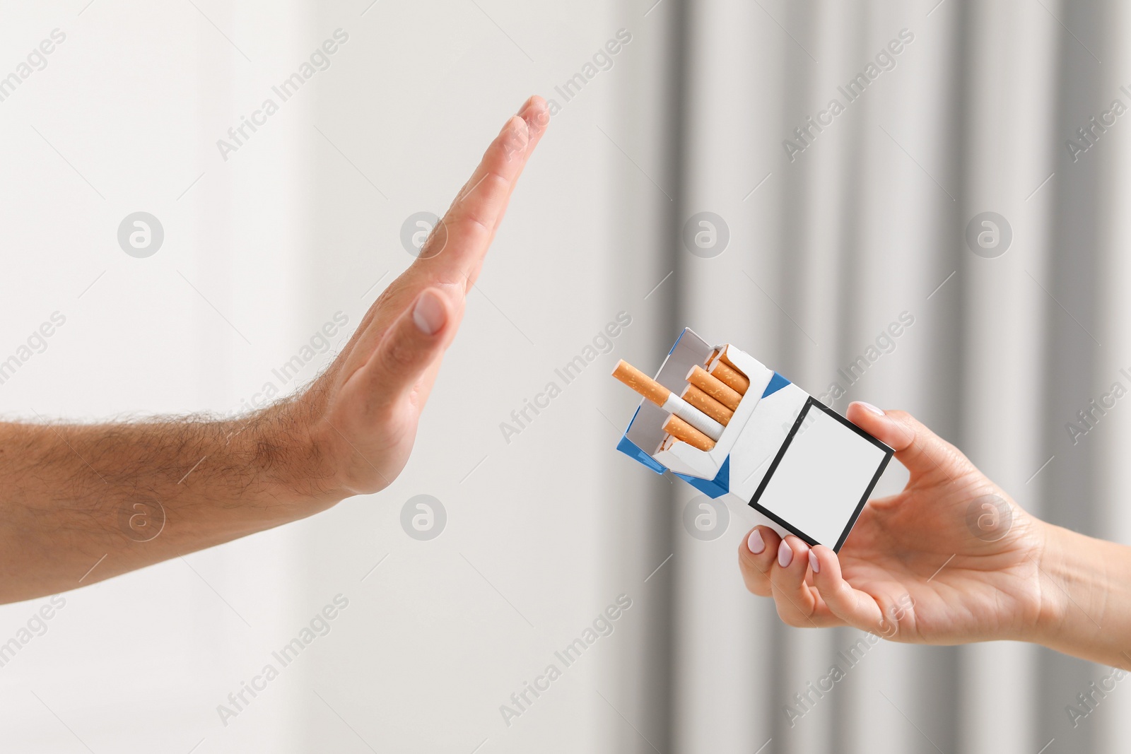 Photo of Stop smoking concept. Man refusing cigarettes on blurred background, closeup