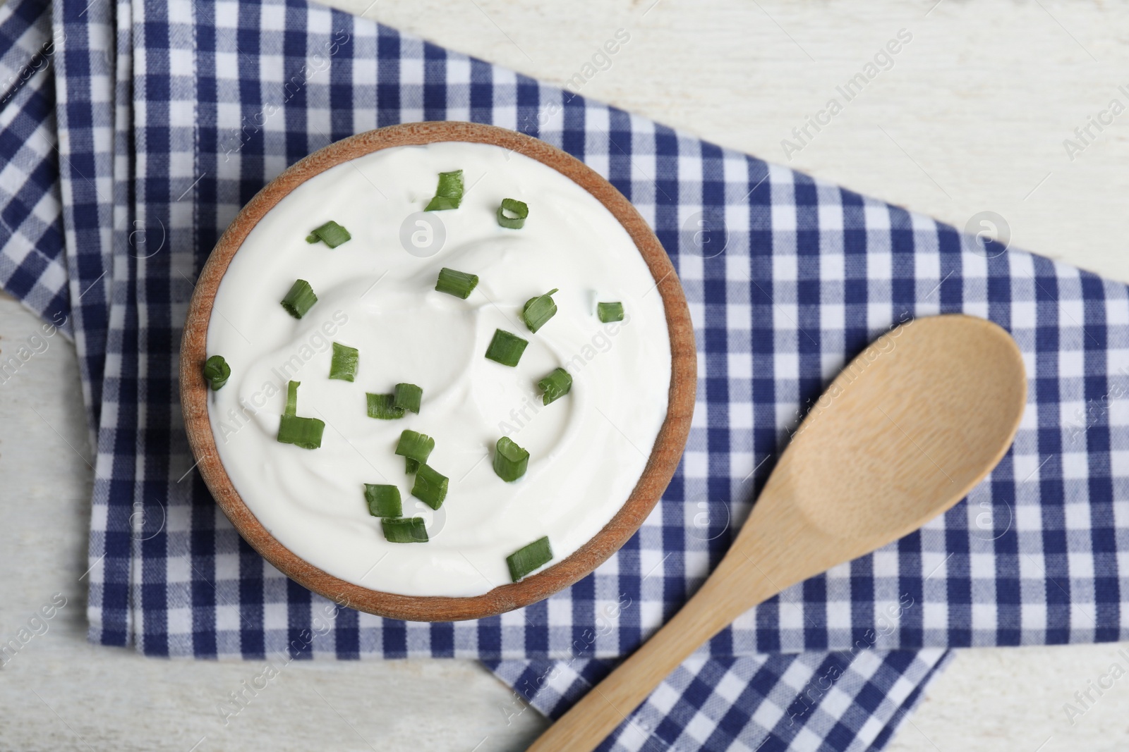 Photo of Fresh sour cream with onion on white wooden table, flat lay