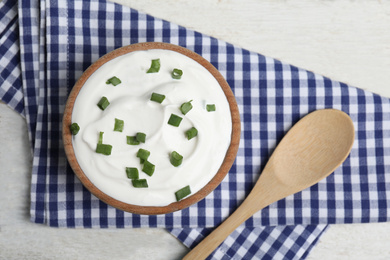 Fresh sour cream with onion on white wooden table, flat lay