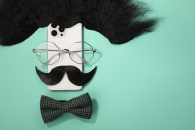 Photo of Flat lay composition with artificial moustache and glasses on turquoise background, space for text