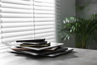 Many different modern gadgets on grey table indoors. Space for text